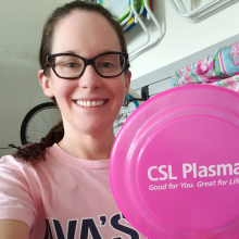 Woman holding frisbee after donating plasma