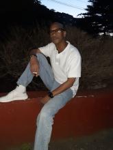 Darryl Davis sitting on red cement wall